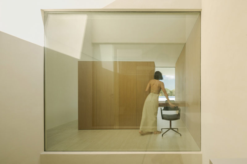 Minimalistyczny dom otoczony wzg&oacute;rzami i lasami. Na dachu – ogromna tafla wody.